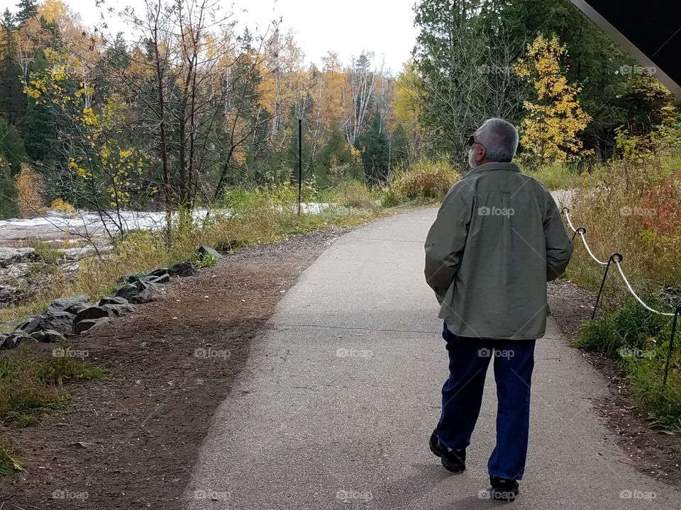 Baby boomer walking along river path