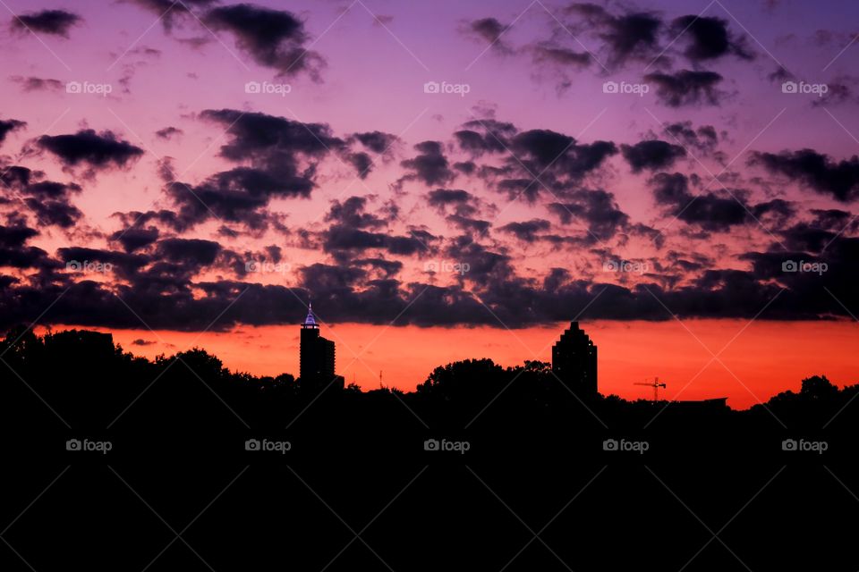 A colorful early morning sky with scattered clouds greets downtown Raleigh North Carolina. View from Dorothea Dix Park. 