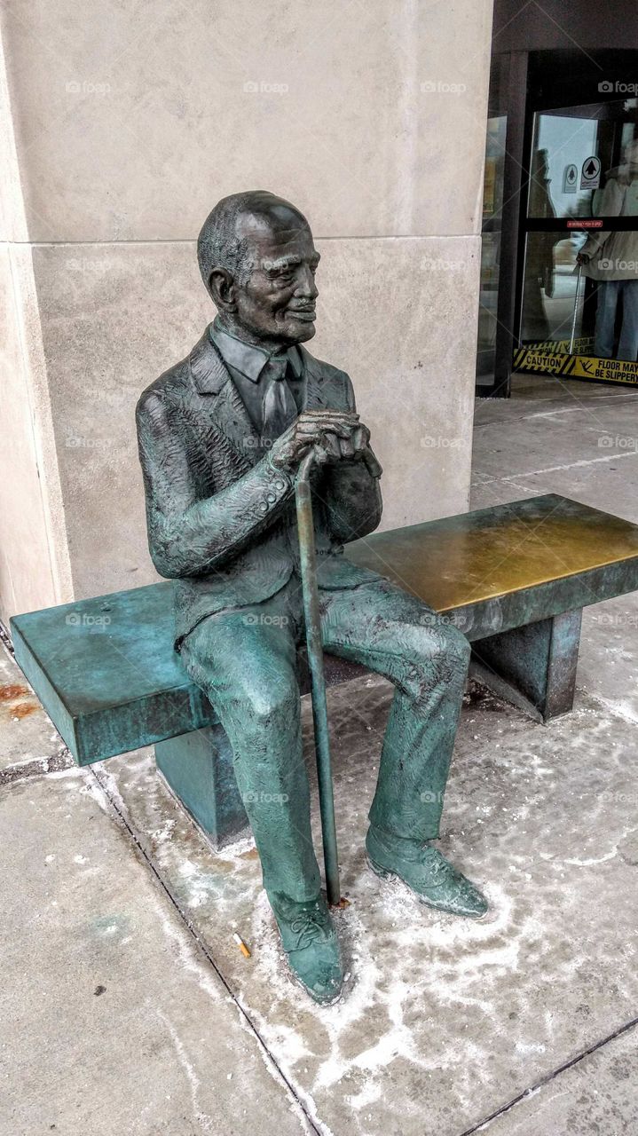 Old man and a Cane statue
