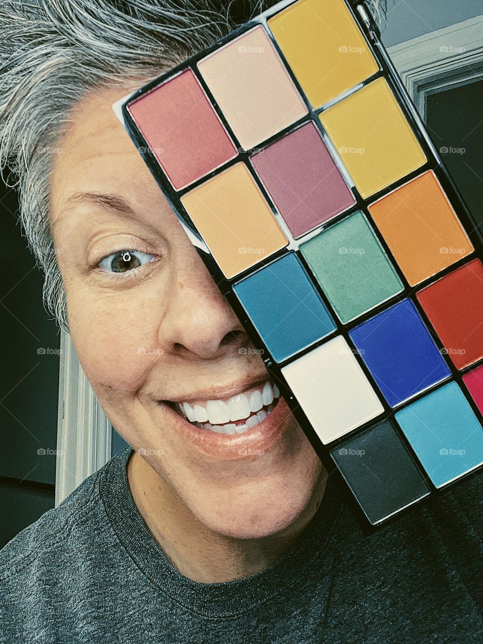 Female having fun with eye shadow, peek a boo with eye shadow, hiding behind the shades of color, woman being silly with makeup, eyes and eye shadow, choices of color