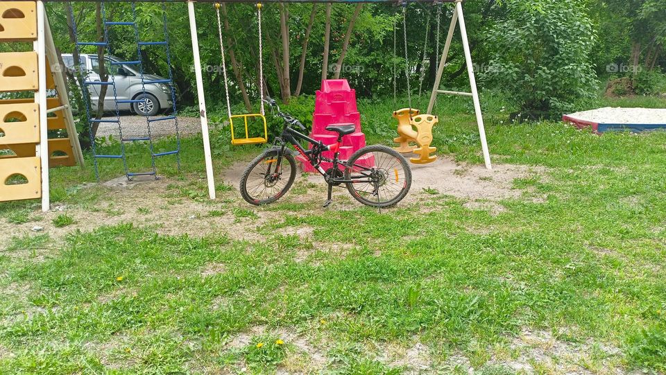 bicycle on the playground, deserted, yard, lawn yellow, red, green, summer, terlyc sunny day