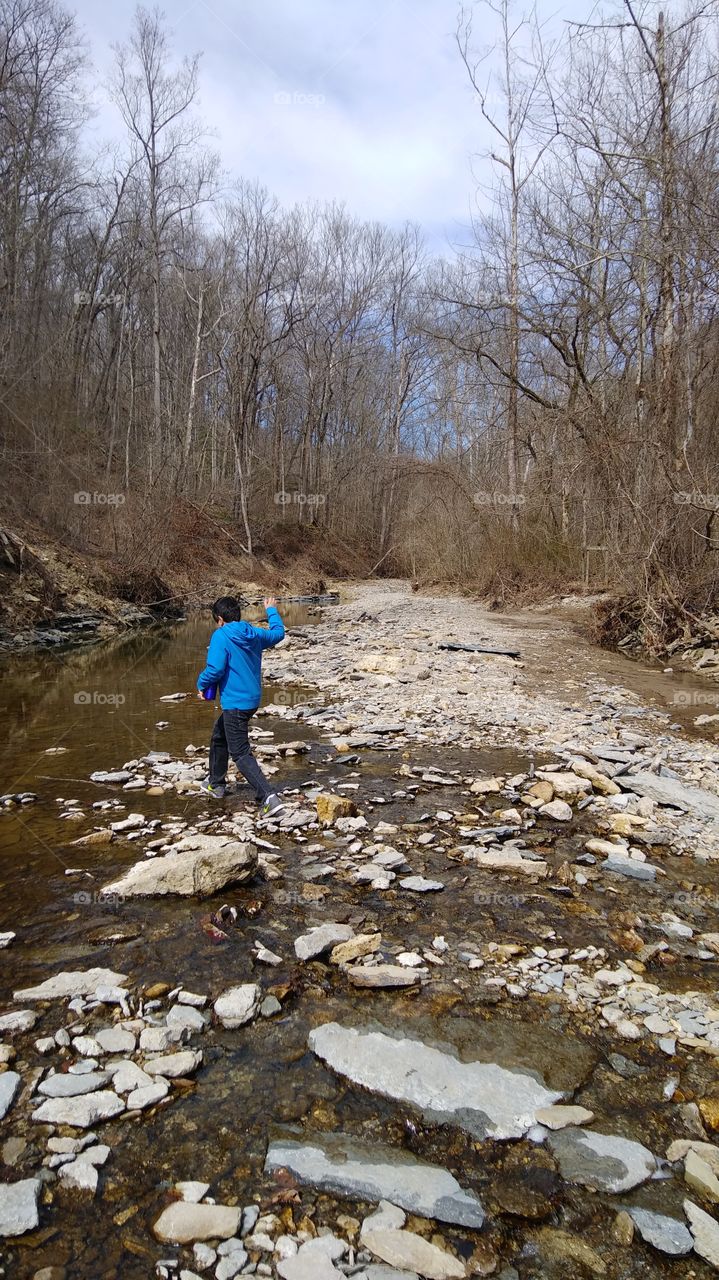 Rock hopping in a creek bed to enjoy the crisp Spring air. The best way to enjoy life is being outdoors.
