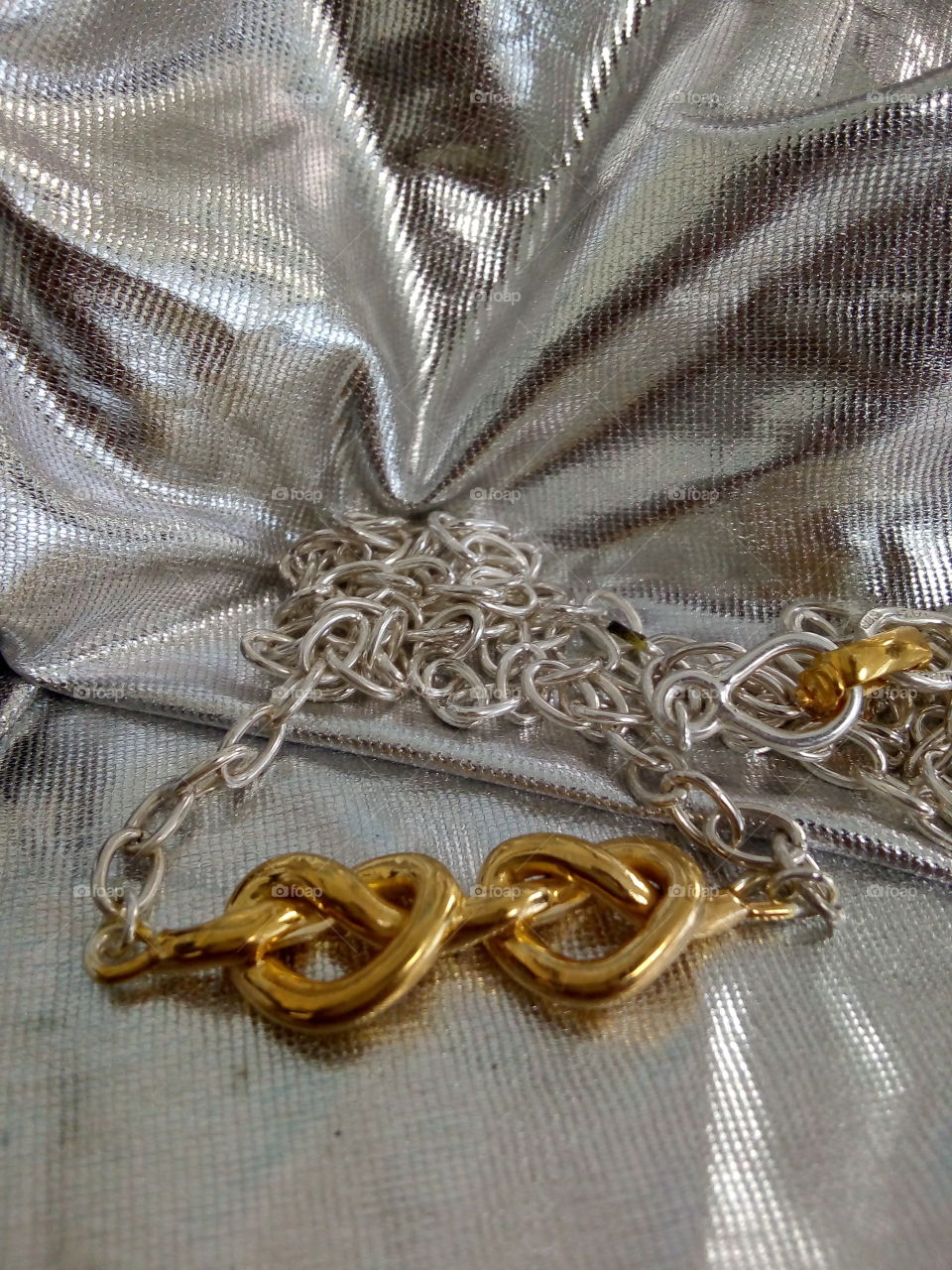 dije de dos corazones unidos, con cadena. Elaborados en plata ley con una capa de oro de 18 k.