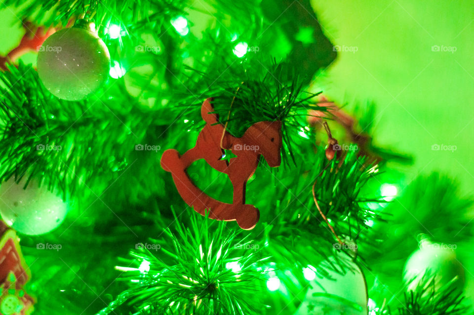 Red wooden horse as a Christmas tree decor element 