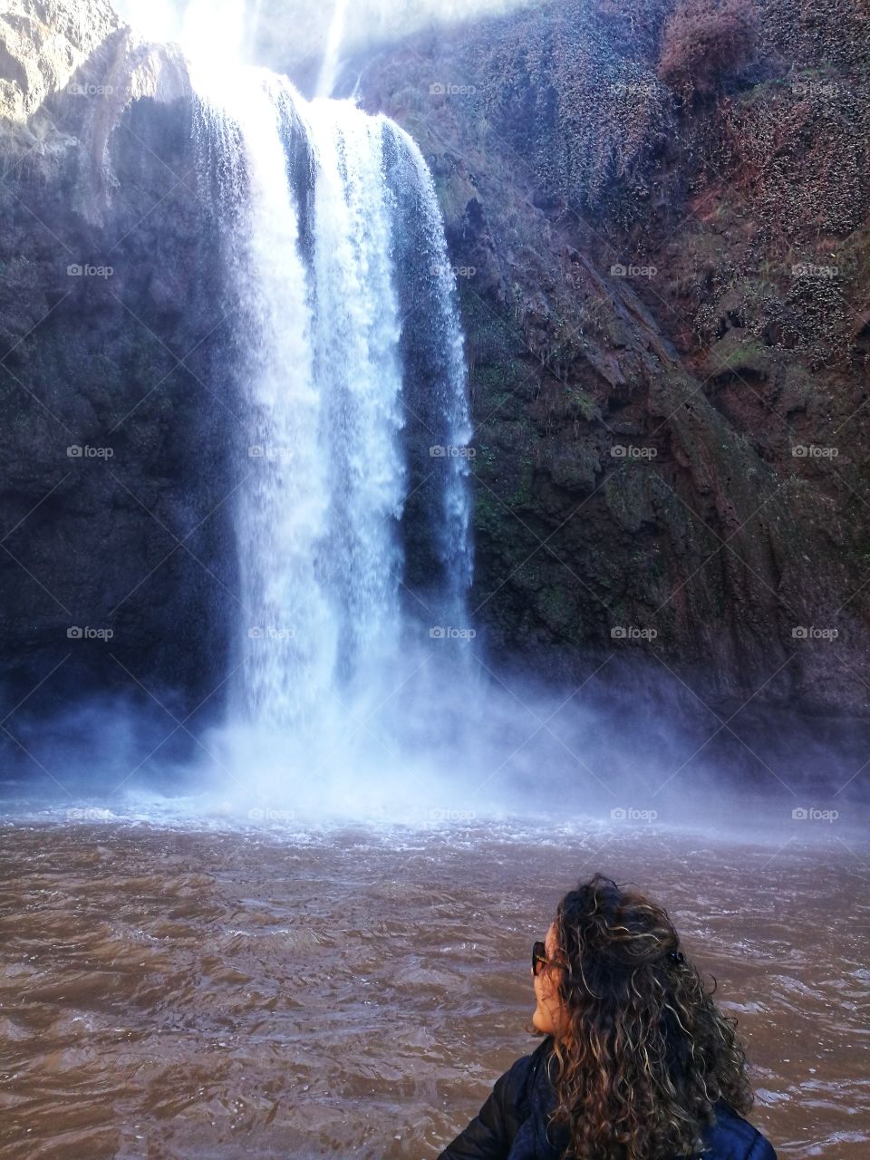 woman looks at the splash of Ouzoud waterfall Morocco