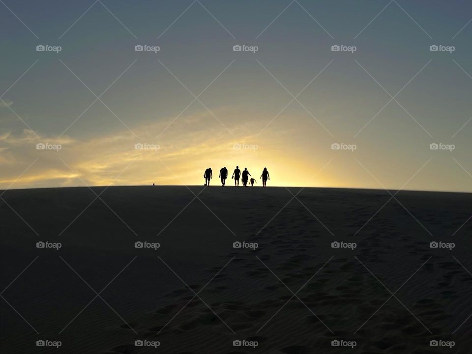 People walking on the dunes in the distance.