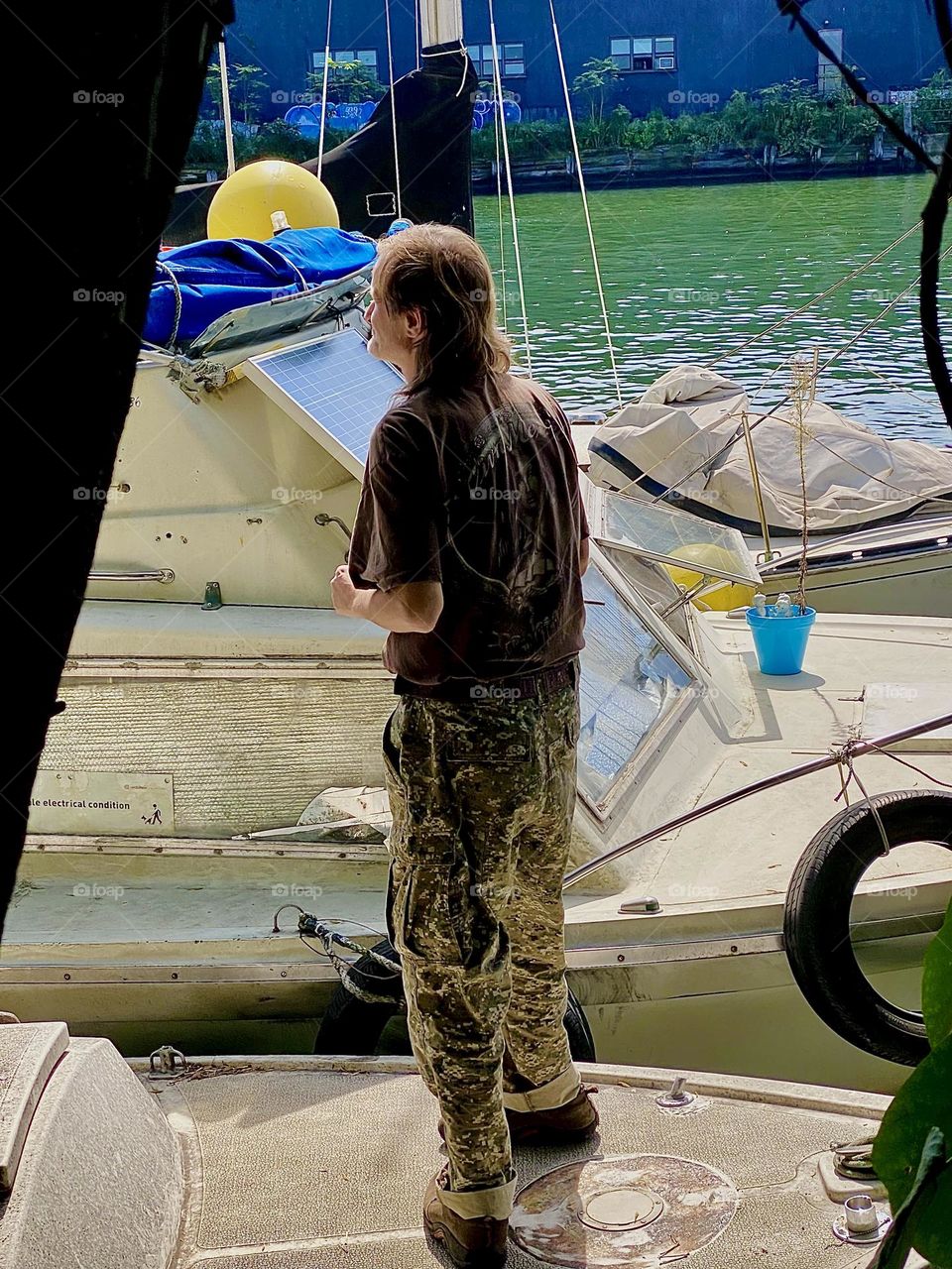 Here he is standing on the neighboring cross over boat to “Salvation”, our “28 foot 1969 Luhrs” cabin cruiser, “Timothy Trespas”, my longtime partner and friend checking out the scenery. 2023. Hypnotic Productions