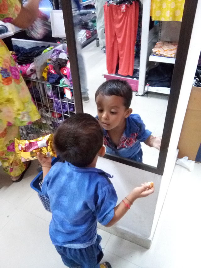Little boy playing with mirror.