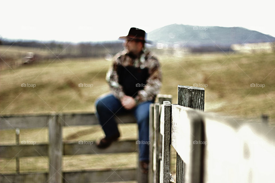 Man sitting on the wooden fence