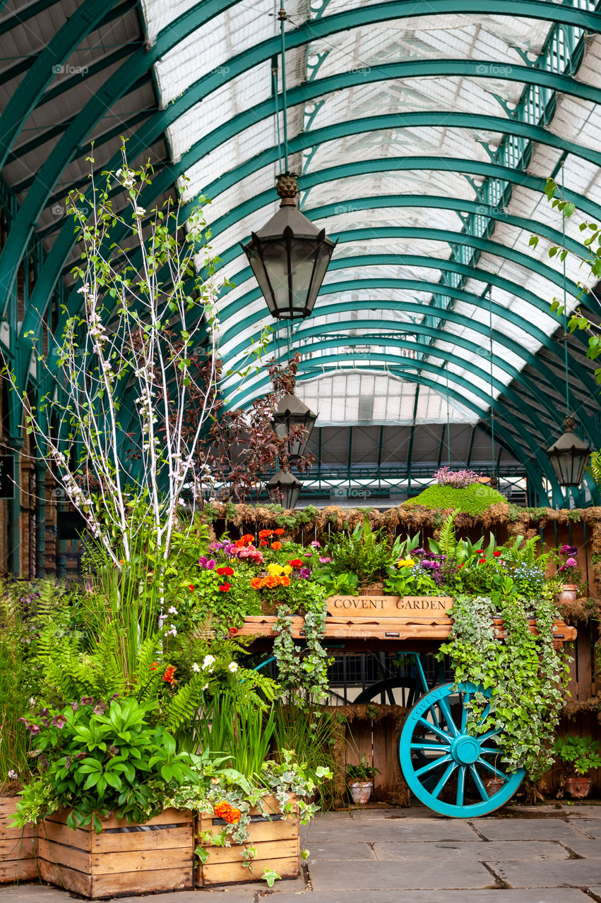 Cart full of flowers on display in old flower and vegetable market place. Covent Garden Market. London. UK