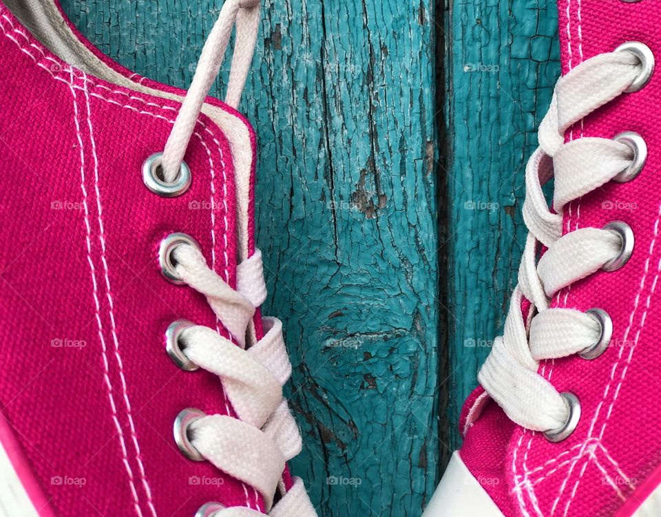Pink sneakers on the wooden background 