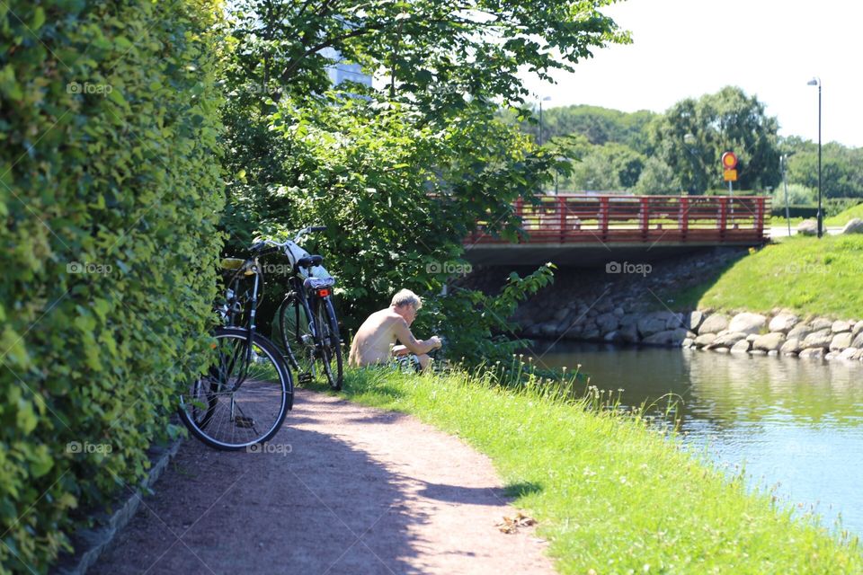 People sitting by the canal and the bridge 