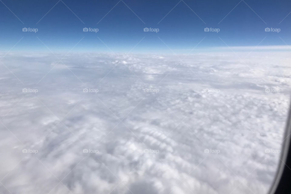 Aerial view of cotton candy clouds below.