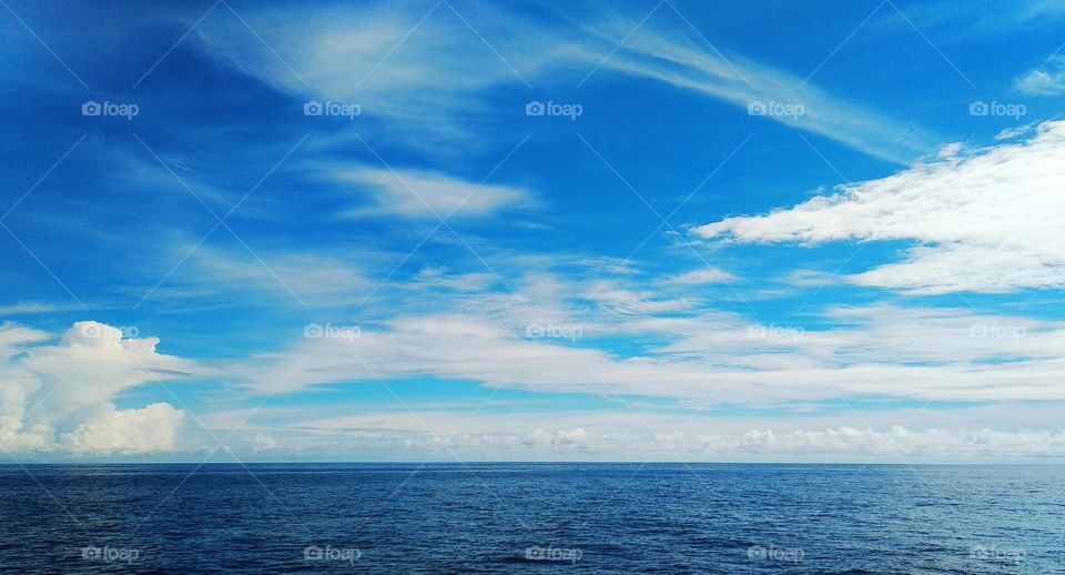 Cloudscape on the sea, a beautiful combination of clouds adorn the clear sky.