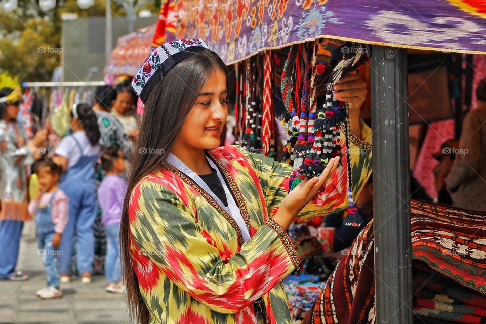 independence day in Uzbekistan. On the day of the holiday, people honor traditions by dressing up in national costumes and organizing fairs with performances.  in the photo of a girl in national festive  dresses.