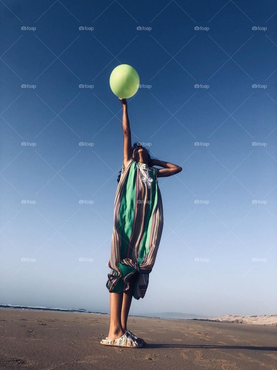 Beautiful girl holding the green balloon 