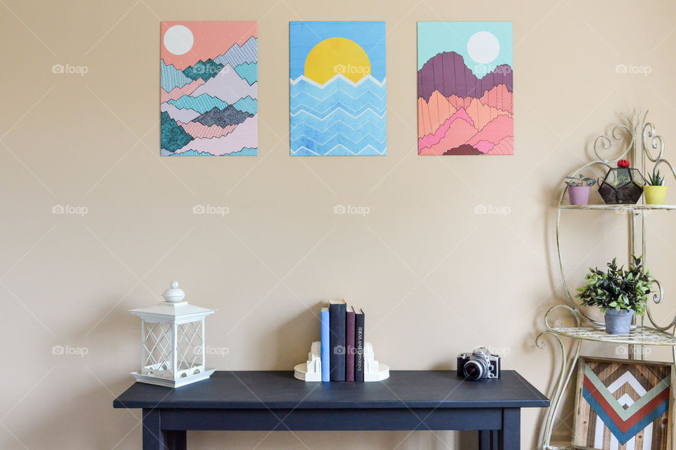 Graphic wall art series displayed above a table and shelving