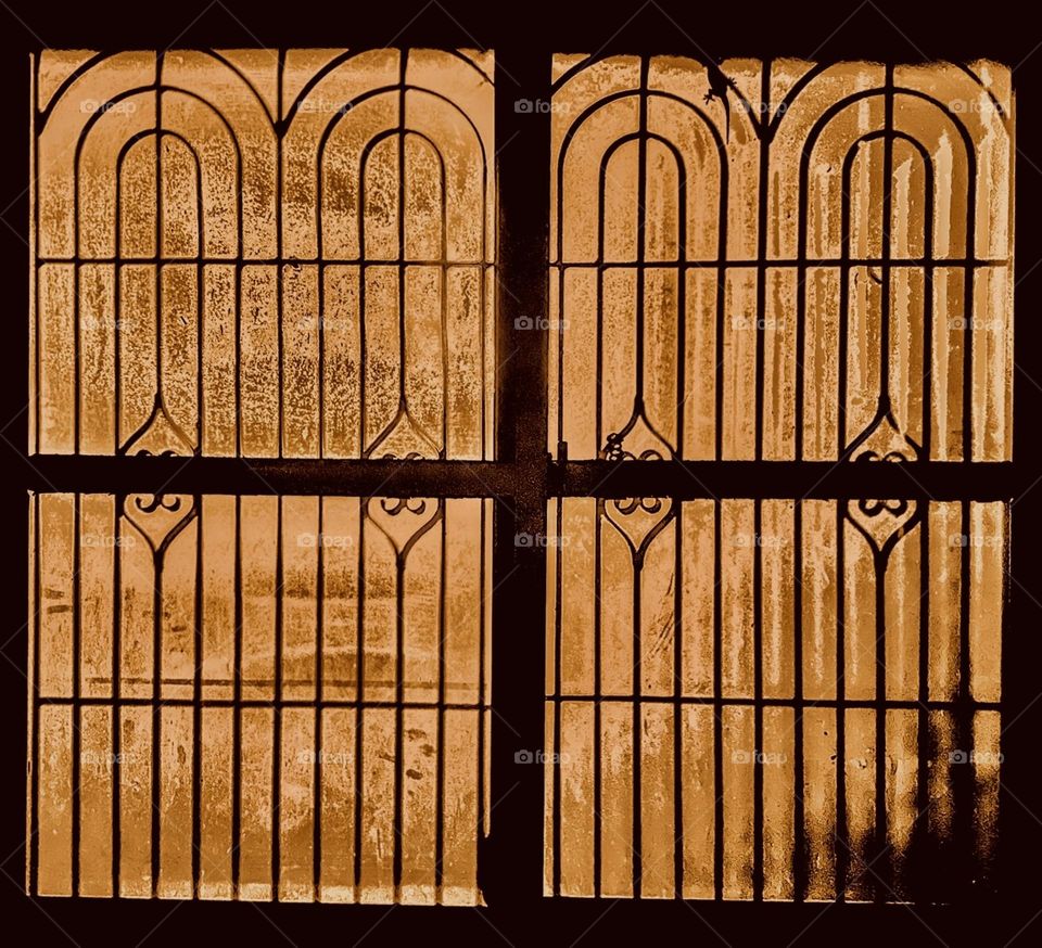 A close up of a closed window - warm light inside the  house - holy cross protection 