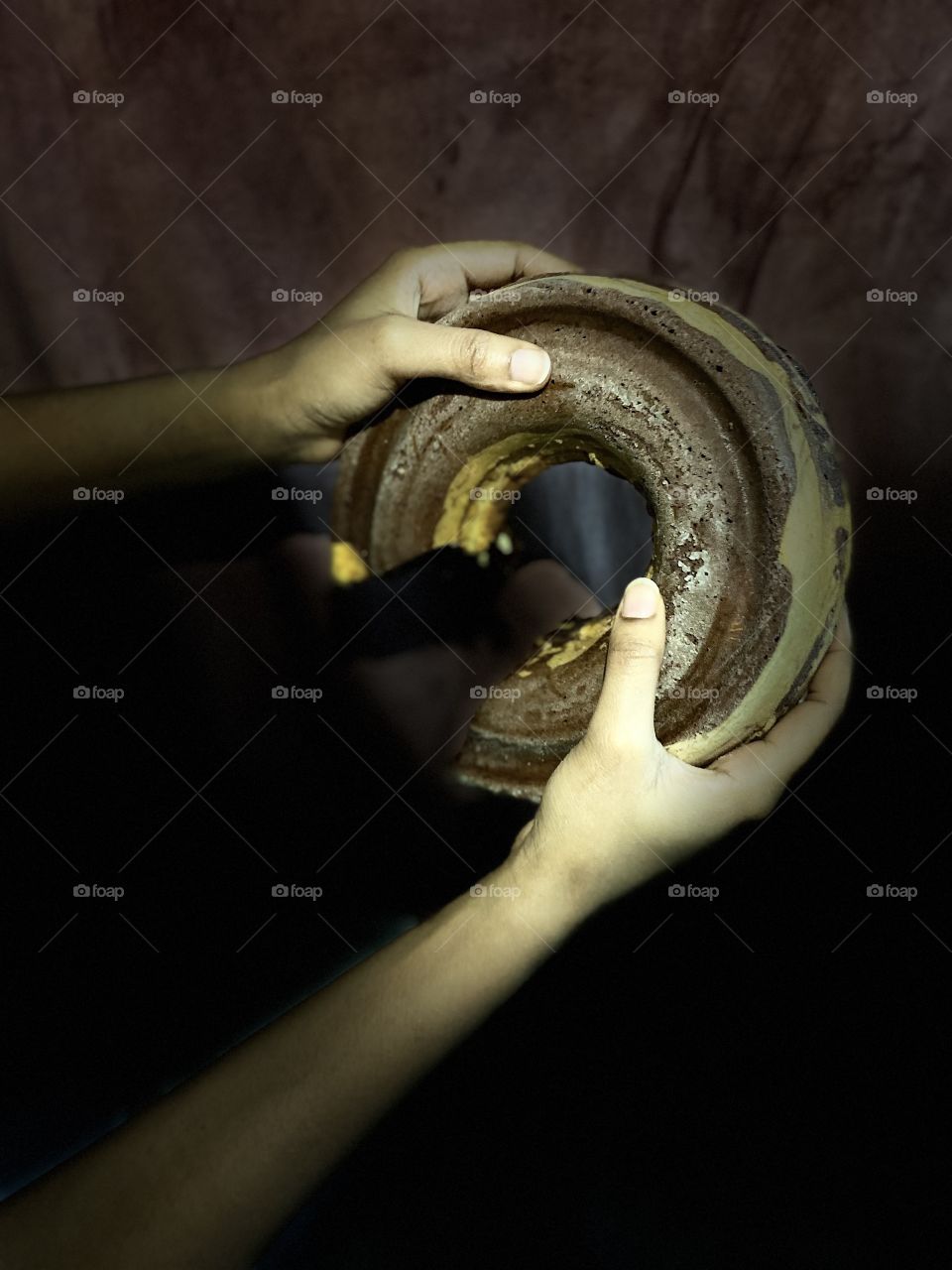 My sister holds the cake in her two hands and wants me to take a picture of it