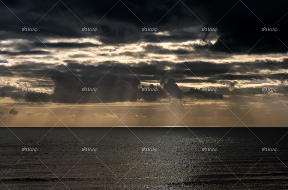 Storm clouds roll in across the English Channel, blocking the late afternoon sun