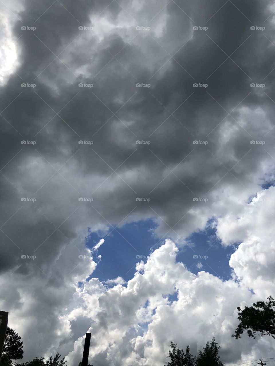 Am incredible clouded up sky with two blue holes in it. 