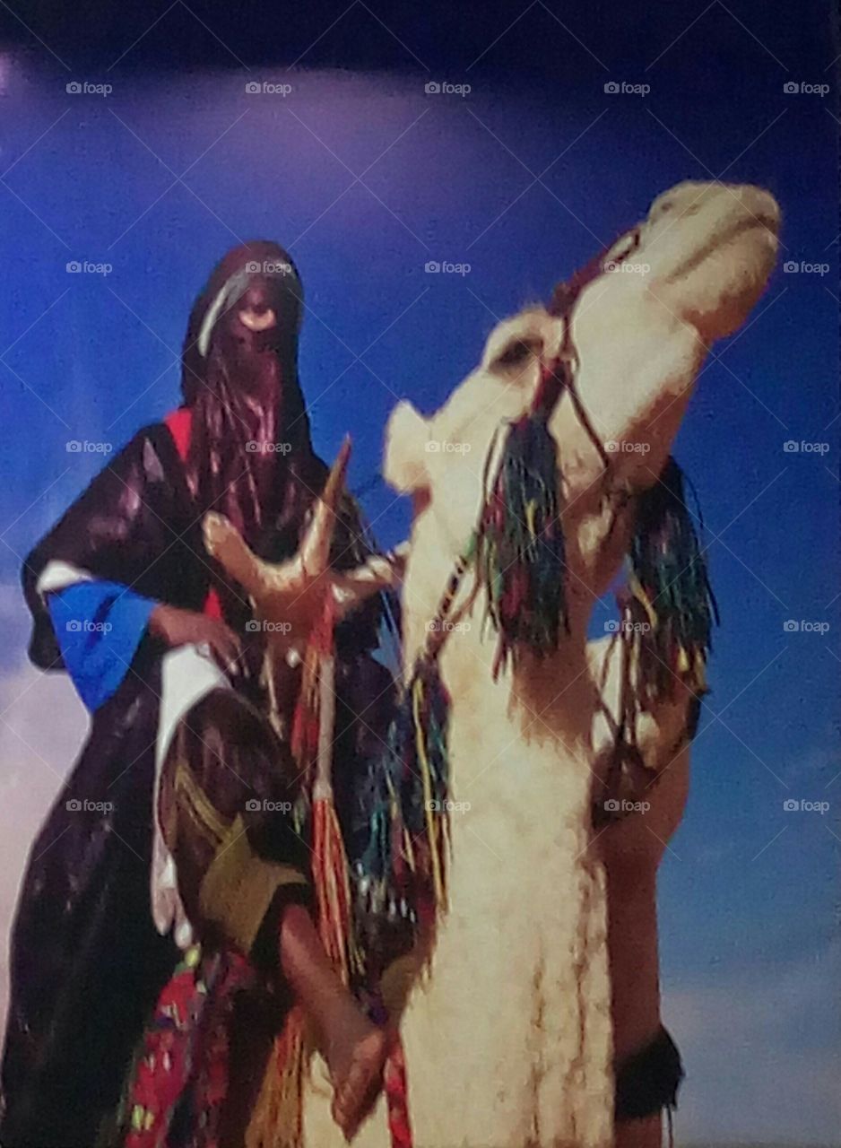 A blueman riding a camel