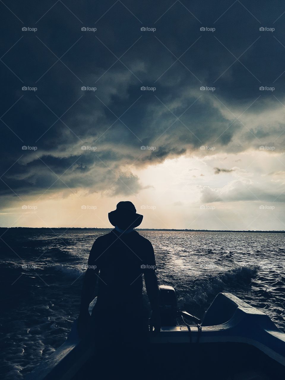 Fleeing from the thunder storm chasing behind. A fisherman's boat speeding away to get away from the heavy clouds building behind. Rainy day, rainy season, the eastern monsoon time in the northern part of Sri Lanka.