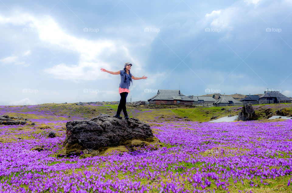 Smiling woman standing on rock