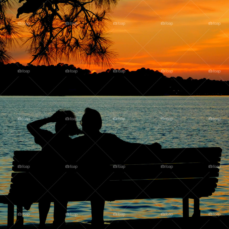 Memorial Day Sunset! A couple relax on a bench in a park during a Memorial Day celebration!