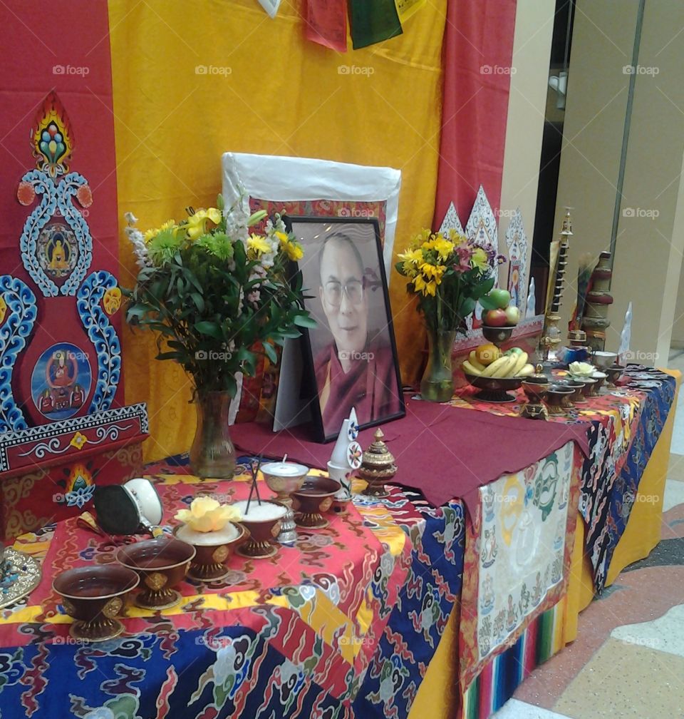 Tibetan Buddhist Altar with Photo of HH the Dalai Lama. Traditional Offerings Placed by Monks of Drepung Loseling Monastery, South India.