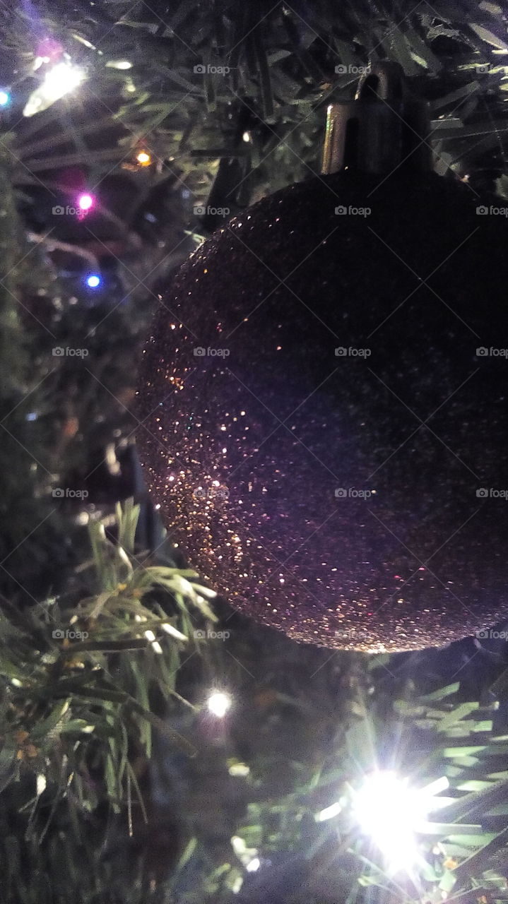 Esfera navideña con luces en un árbol de Navidad.