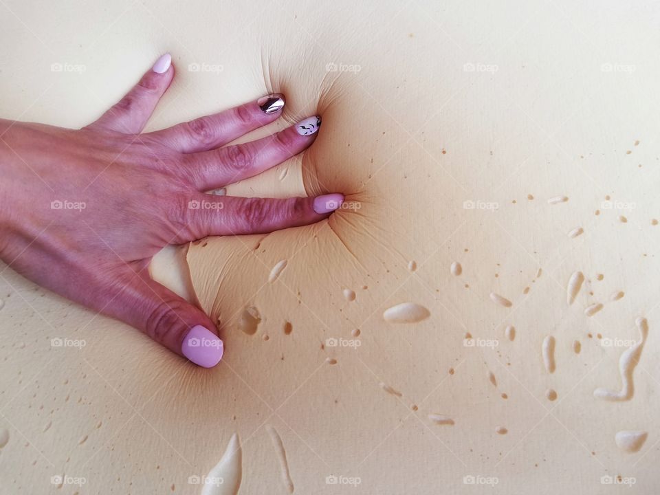 Woman's hand sinks onto a memory foam mattress