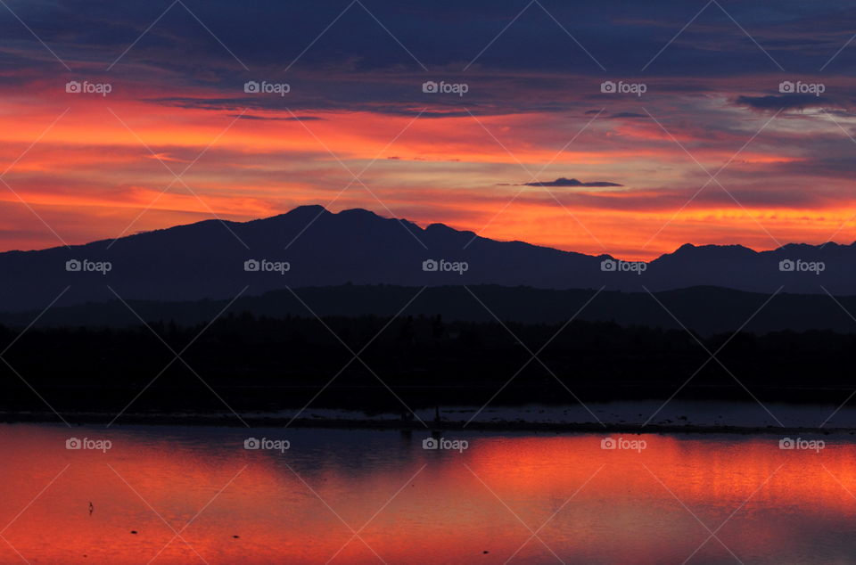 Sunset. Mountain low speed captured for the times of summer at the surround of mangrove. But, this is to show the mountain of north, when looking on beauty reflection. A colour of sunset in red- oranje and black.