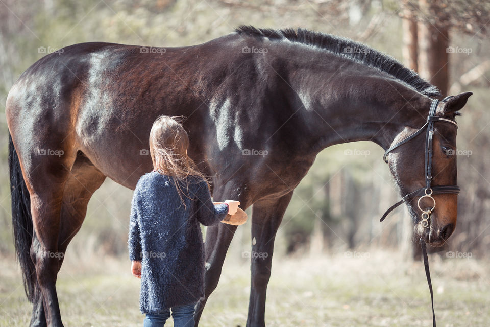 Little girl with horse, outdoor portrait 