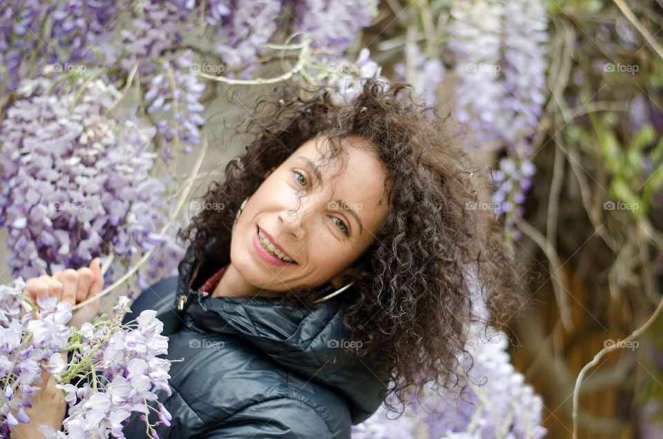 Smiling woman on a background of Wisteria