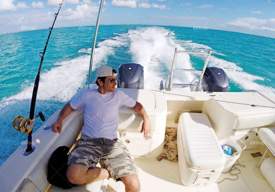Man travelling in boat on blue sea