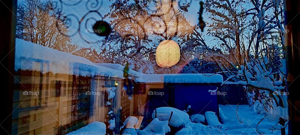 This is a view onto the snow covered garden of the lovely house in “Bavaria”, Germany through the glass facade with sliding door of the living room. The blizzard of early December 2023 has left a thick cover of snow everywhere. Hypnotic Productions