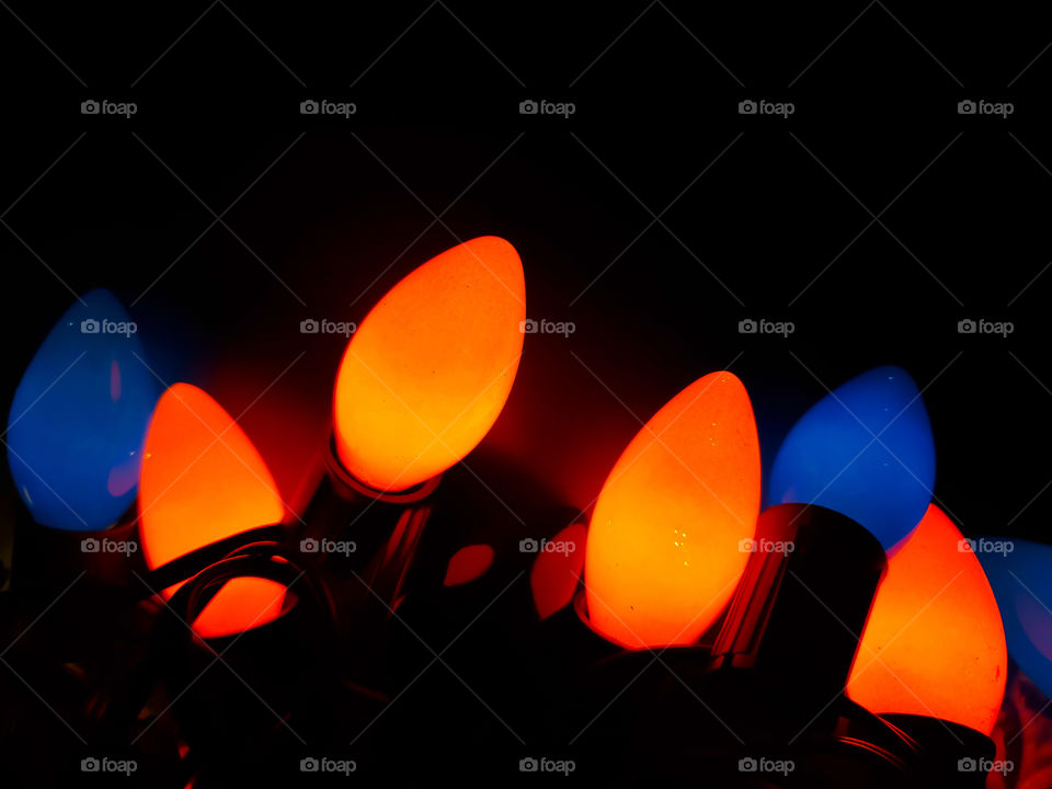 Bright orange and blue vintage C9 ceramic light bulbs illuminating the dark