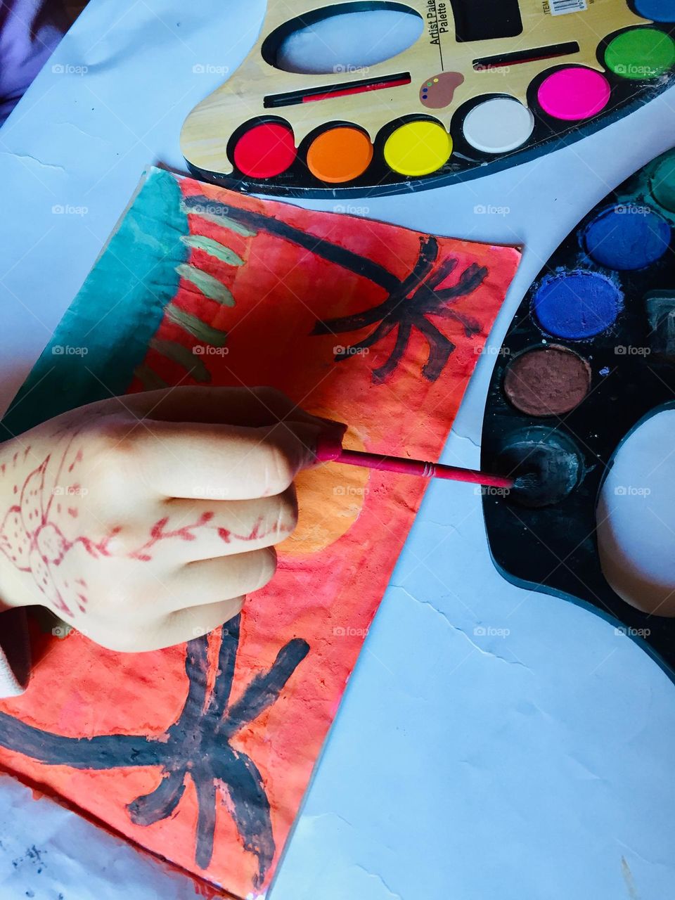 A little girl practicing her favorite hobby which is painting