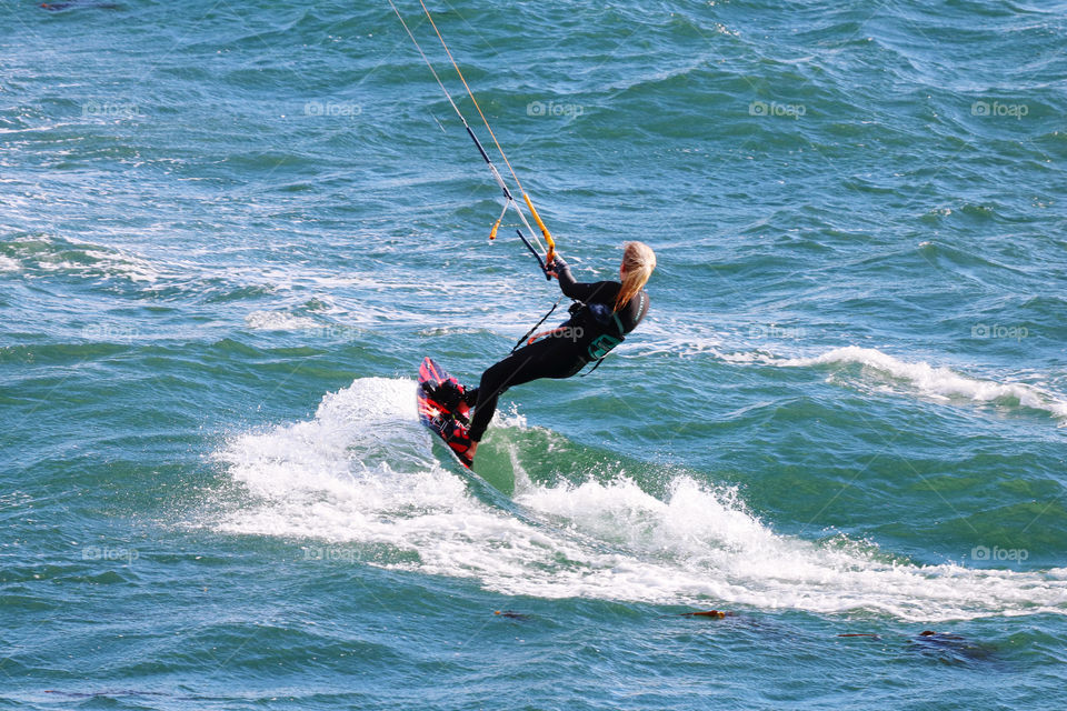 Kitesurfer riding on the windy ocean