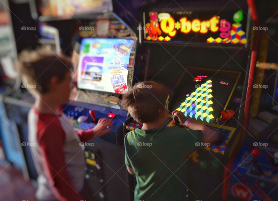 1980s Videogame Arcade. Boys Playing Videogames In A 1980s Vintage Arcade
