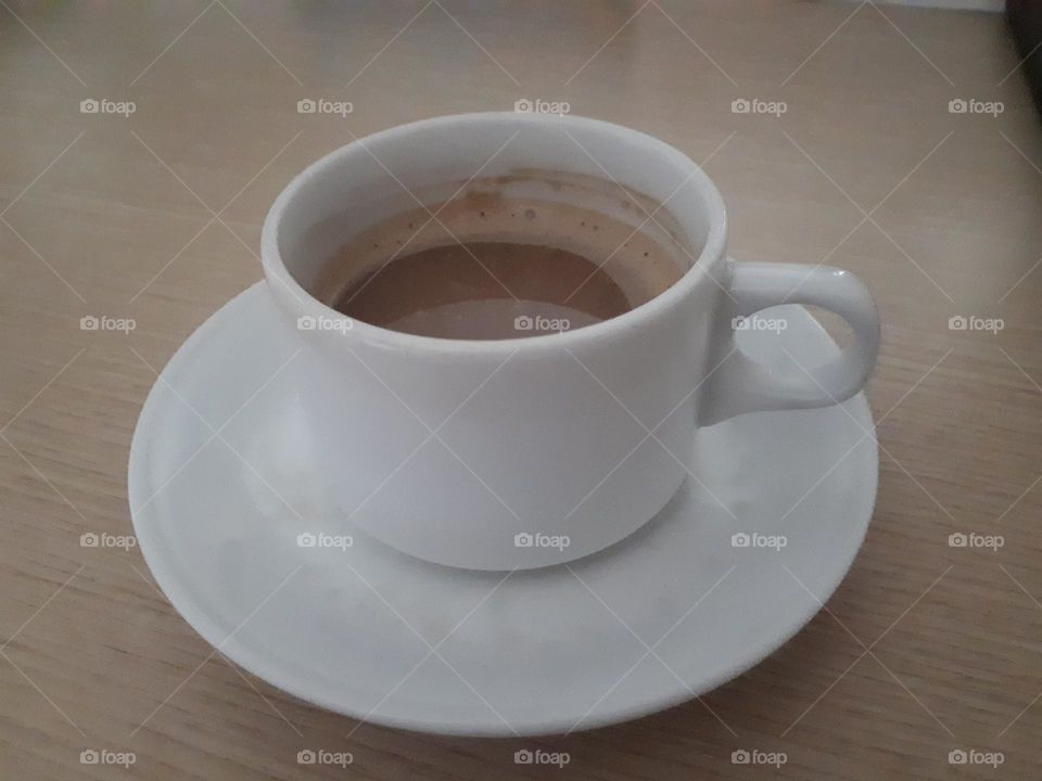 a cup of delicious cappuccino latte coffee served on a wooden table in the morning