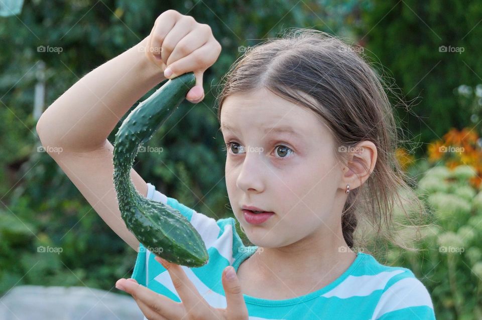 Surprised girl with cucumber