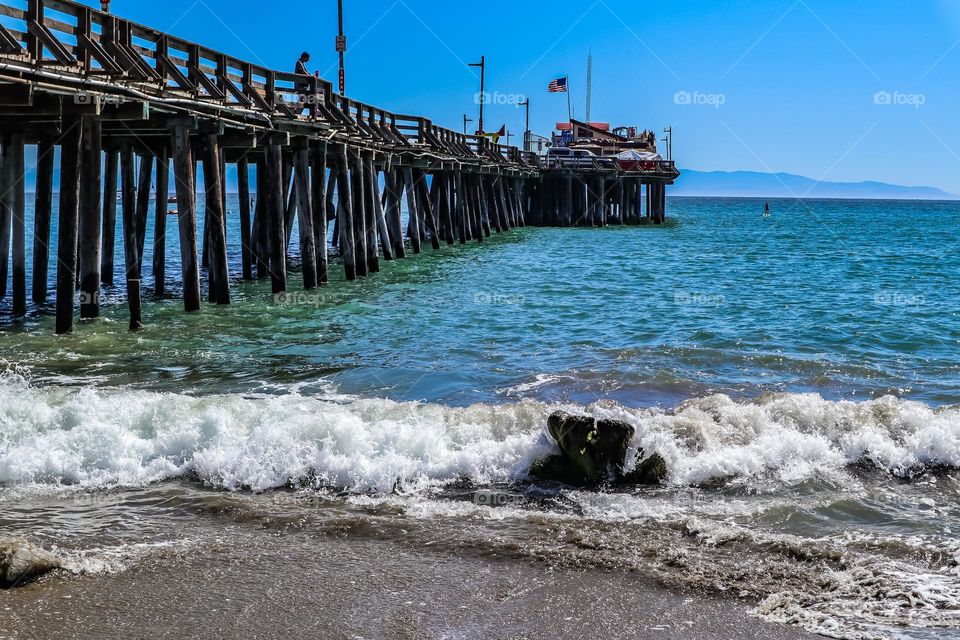 Capitola California wharf and beach on a beautiful sunny afternoon , with the clear blue waters and crashing waves 