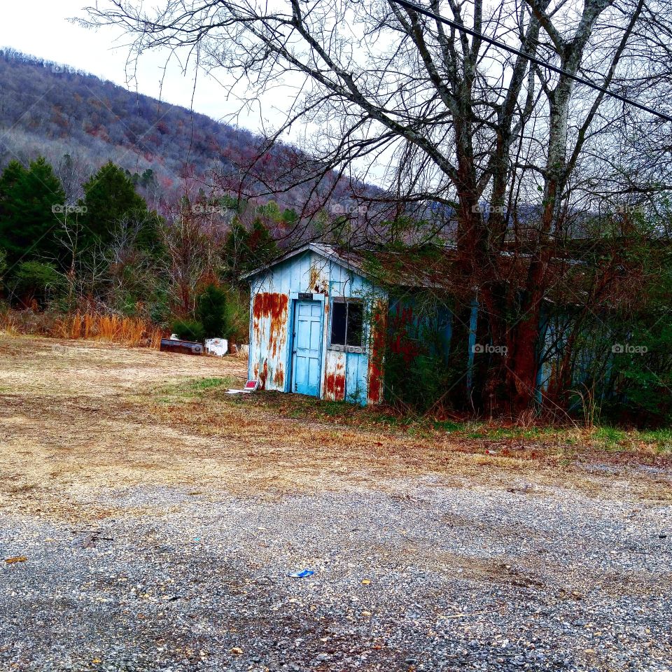 abandoned blue building ​in middle of nowhere