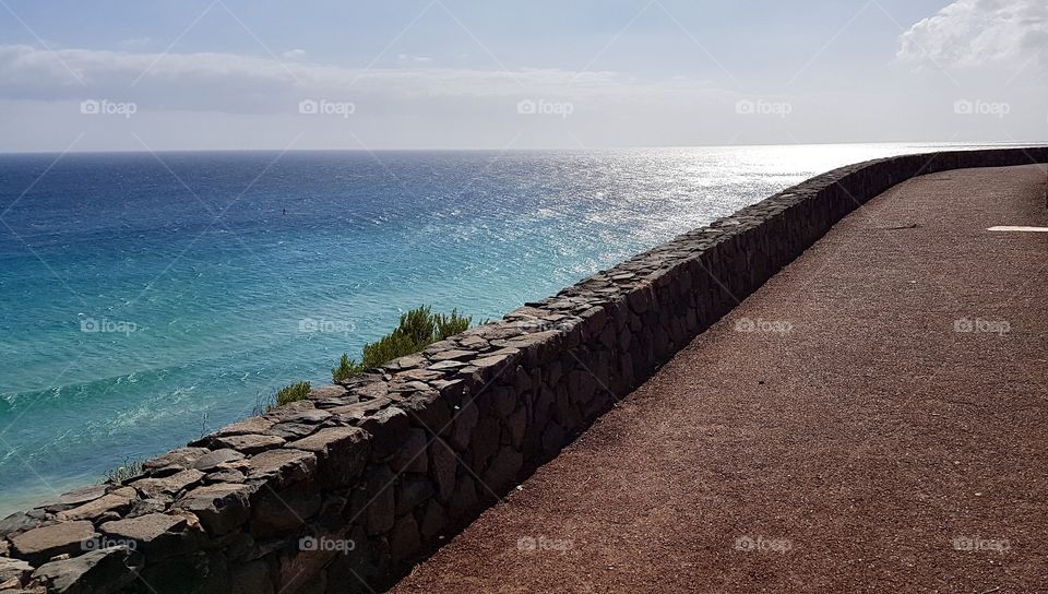 Walking by the sea with view of blue turquoise water in sunny weather, Fuerteventura Canary Islands Spain - promenad vid stranden med utsikt över blått turkost hav i soligt väder, semester Kanarieöarna Spanien 