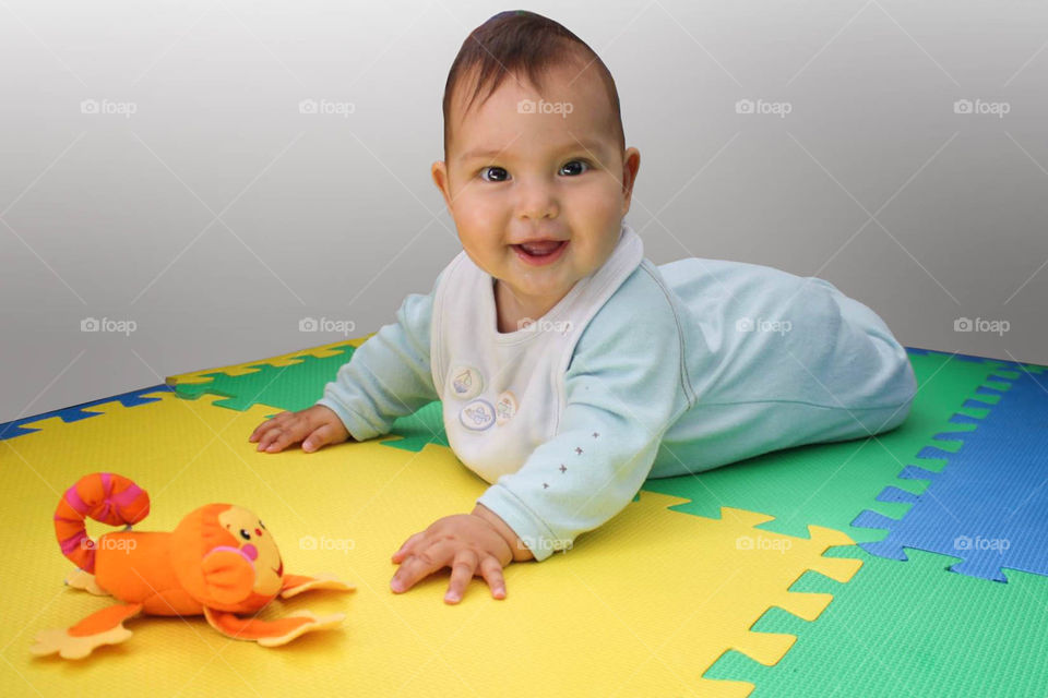 Happy cute baby with her favorite toy monkey by Fisher Price