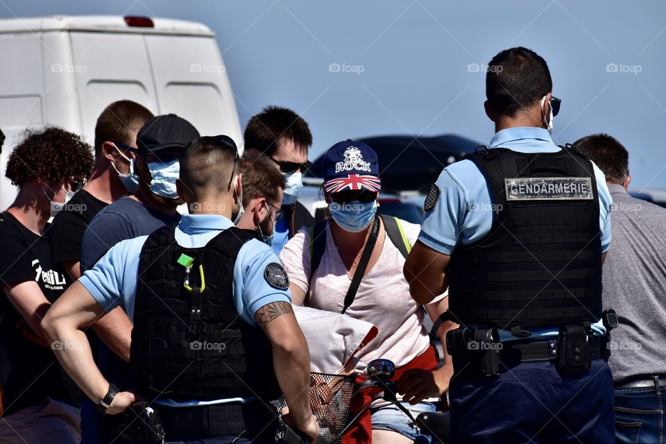 Police with masks controlling tourists with masks