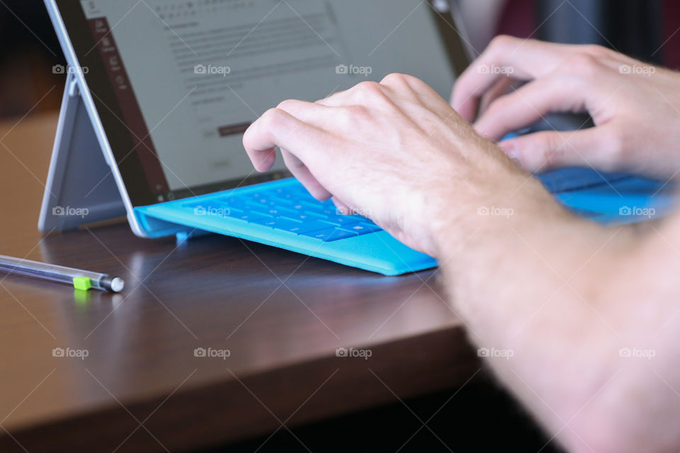 A person typing on a blue keyboard