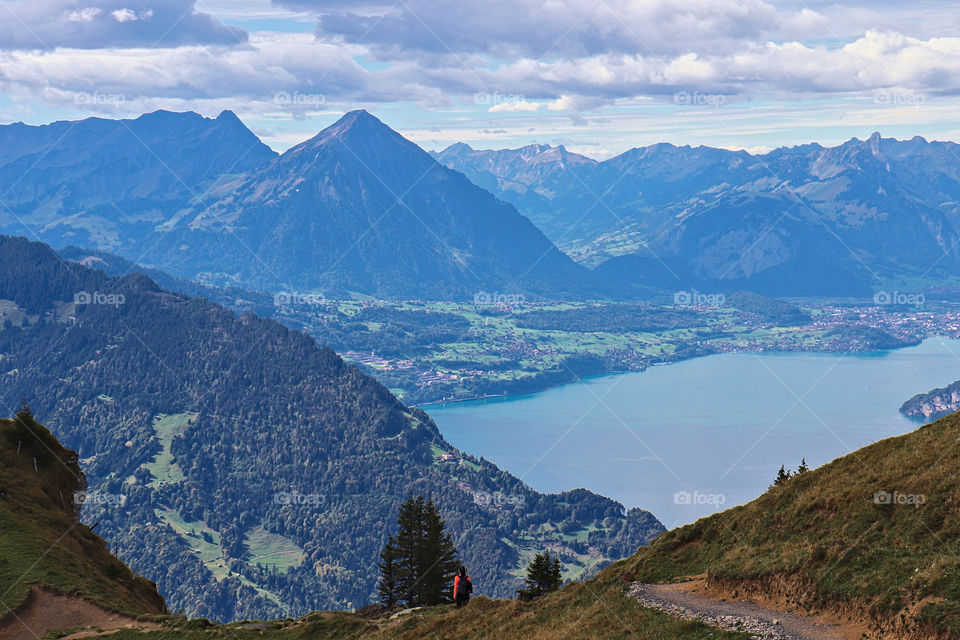 Mountains (Niesen) and lake Thun with hiker in the foreground